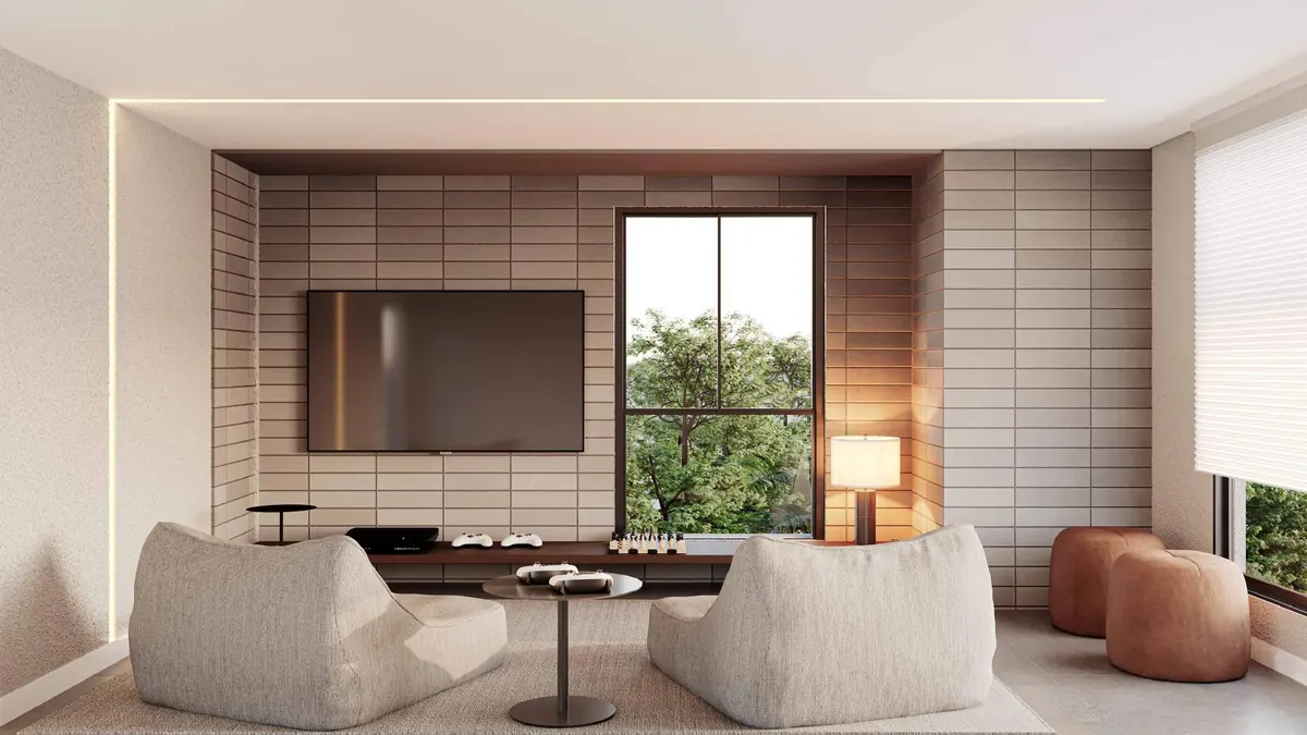 Espaço game room com TV, poltronas e janela para o verde
