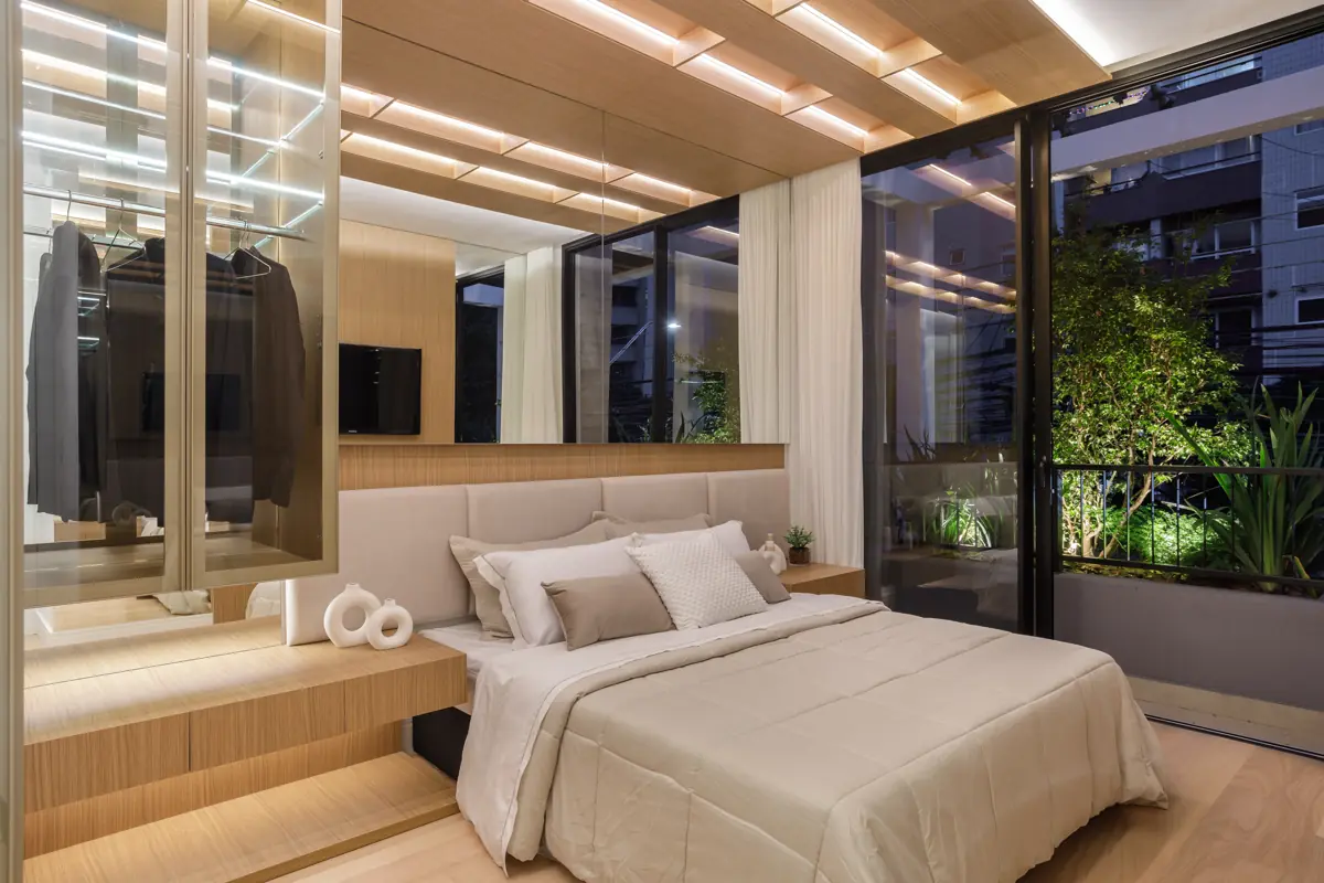 Apartamento decorado do Réve: suíte com forro de madeira iluminado, closet em vidro e jardineira na varanda