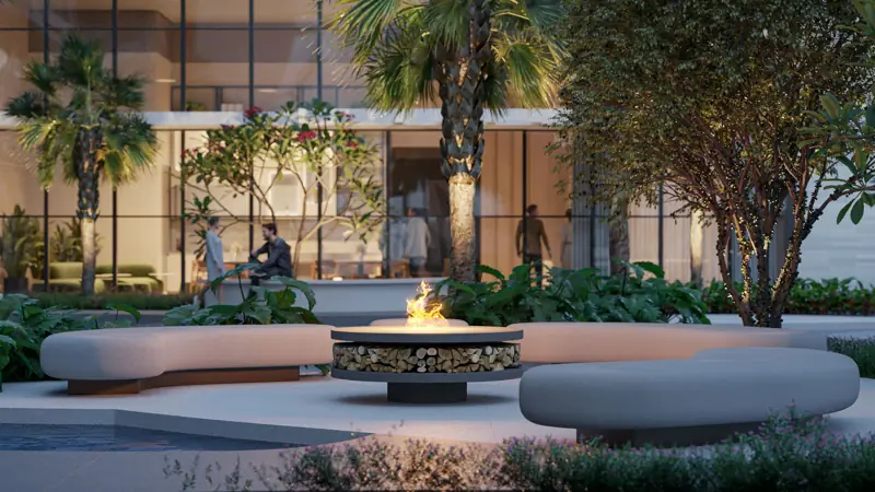 Fire place do Réve cercado por bancos curvos, vegetação e espelho d’água ao entardecer