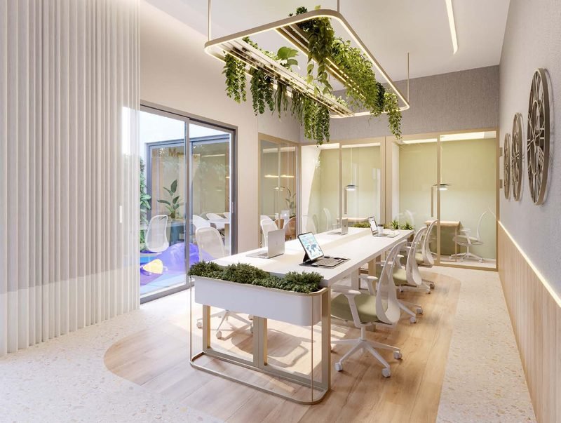 Espaço de coworking com mesa compartilhada e luminária com plantas