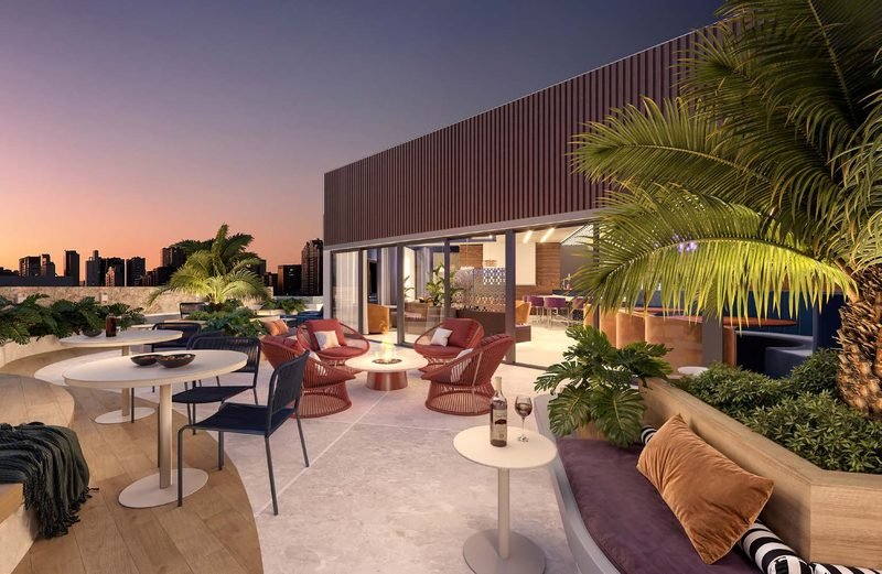 Terraço do rooftop com poltronas ao redor de lareira externa